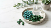 Spirulina and chlorella algae tablets arranged together showing the blue-green and deep green colors of these complementary superfoods for daily wellness