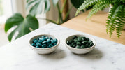 Spirulina and chlorella algae supplement tablets compared side by side showing the color difference between blue-green spirulina and deep green chlorella
