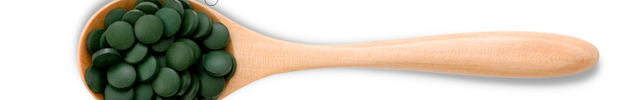 A wooden spoon filled with green chlorella tablets, with text pointing to the tablets highlighting their benefits